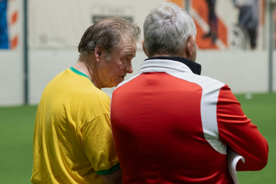 Older Brazilian mentor speaking with a younger person