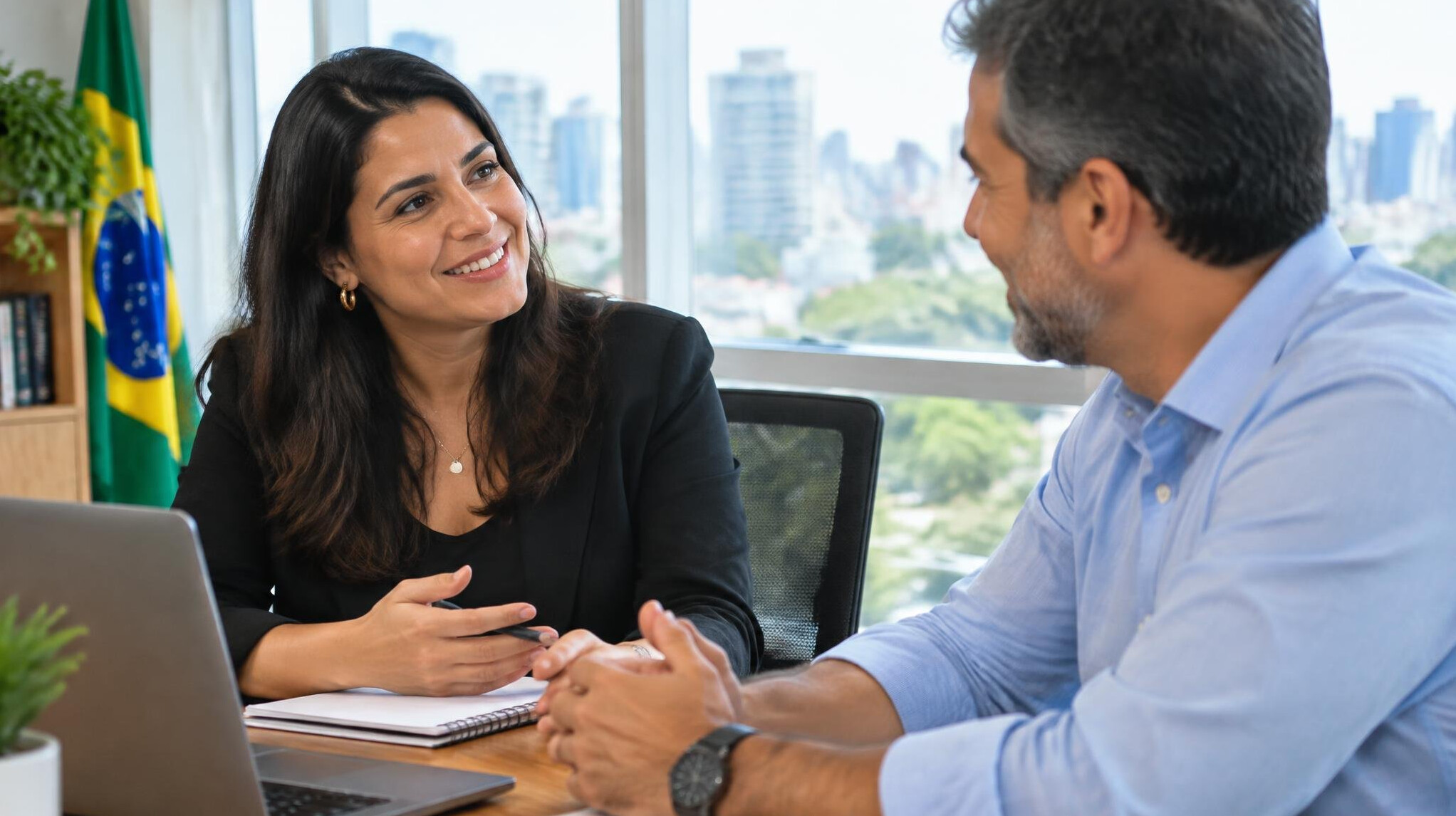 Two Brazilian colleagues having a warm conversation in a bright office