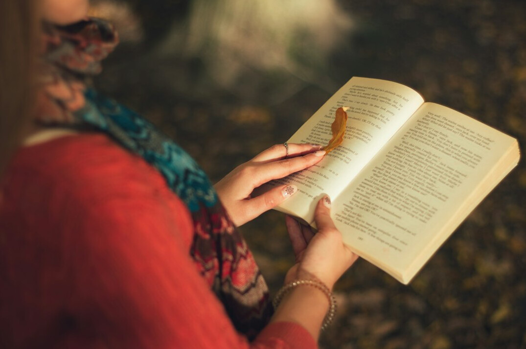Brazilian woman journaling at a wooden desk near a window